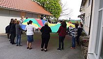 AWO in der Ganztagsschule - Das Bild zeigt die Teilnehmer der Fortbildung beim Spiel mit dem Schwungtuch